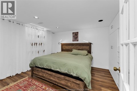 A bedroom with a bed and a rug on the floor.