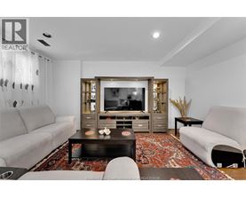 A living room with a grey couch, a black coffee table, and a television.