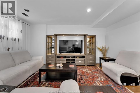 A living room with a grey couch, a black coffee table, and a television.