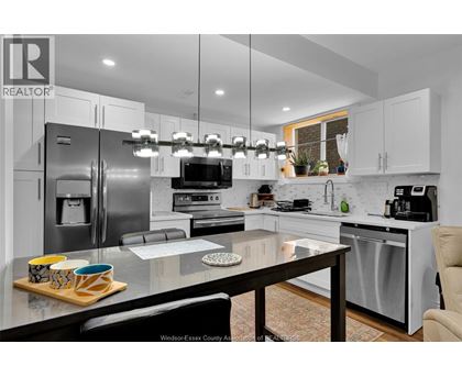 A modern kitchen with a glass table and stainless steel appliances.