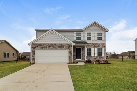 A house with a garage and a driveway in front.