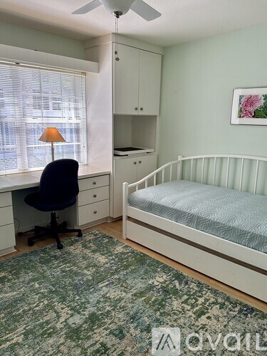 A bedroom with a bed, desk, and chair.