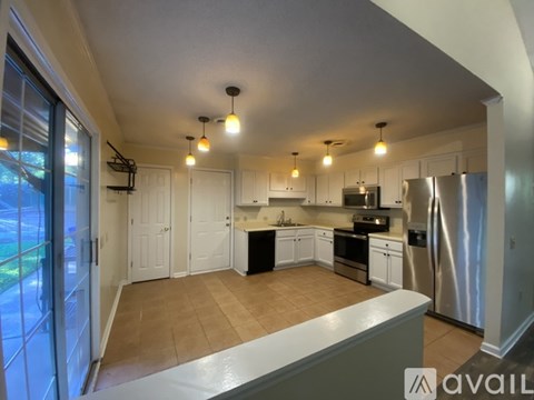 A kitchen with white cabinets and a black countertop.