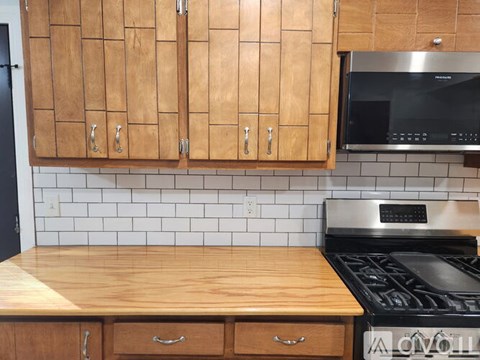 A kitchen with wooden cabinets and a black stove top.
