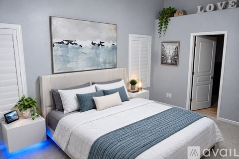 A bedroom with a large bed and a painting on the wall.