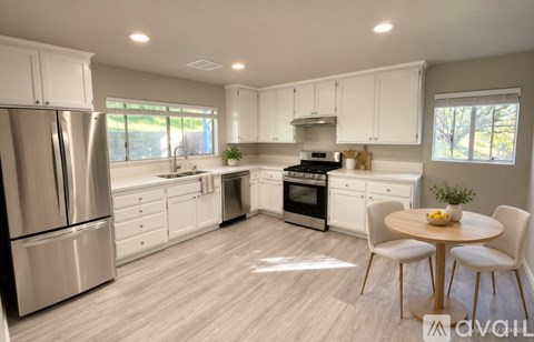 A modern kitchen with white cabinets and stainless steel appliances.