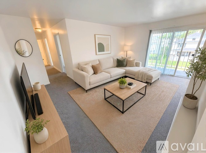 A living room with a white sofa, a coffee table, and a television.
