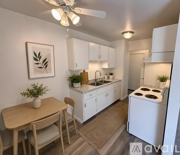 A kitchen with a table and chairs in the foreground and a fridge in the background.