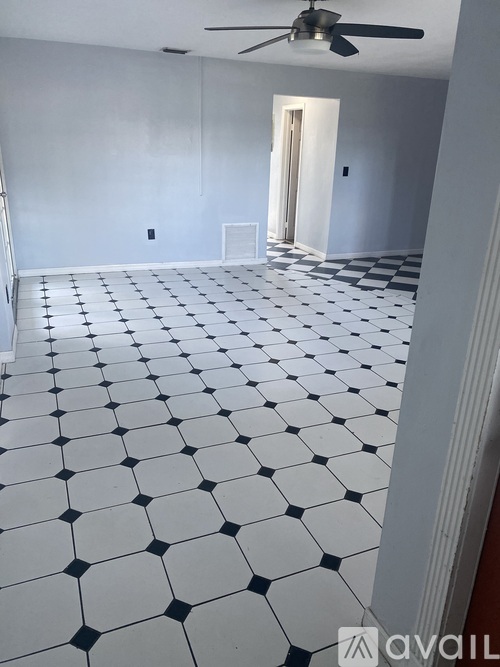 A room with a checkered floor and a ceiling fan.