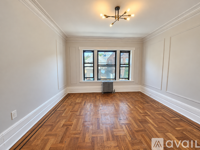 A room with wooden flooring and a chandelier.