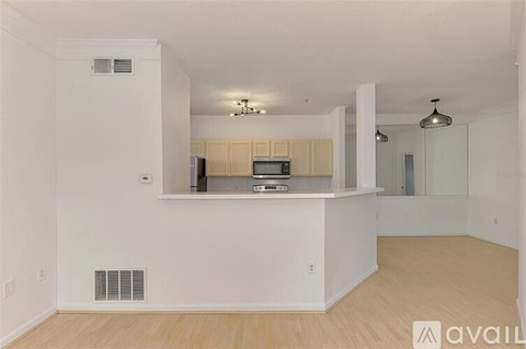 A spacious living room with a kitchenette and a dining area.