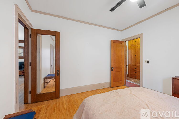 A bedroom with a bed, a mirror, and a wooden door.