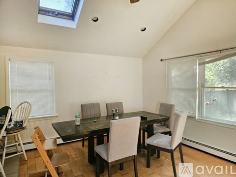 A dining room with a table and chairs.