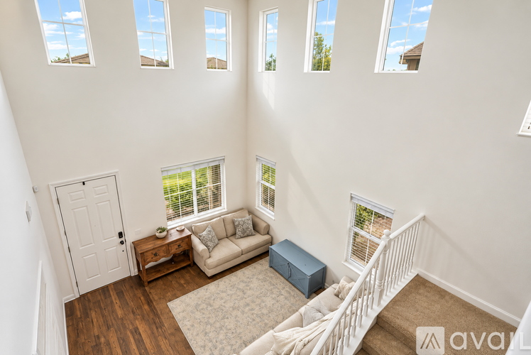 A living room with a couch, a table, and a window with blinds.
