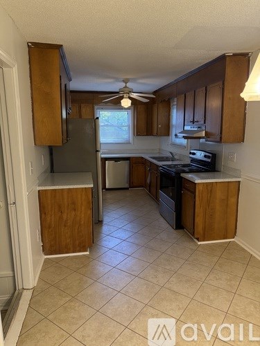 A kitchen with wooden cabinets and a tiled floor.