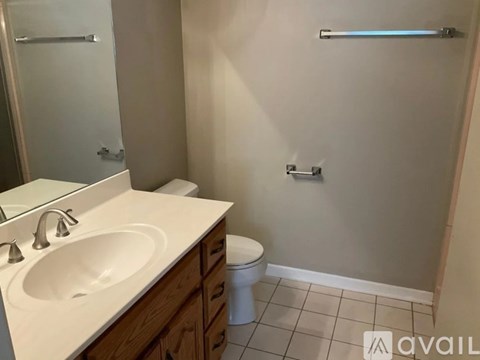 A bathroom with a toilet, sink, and towel rack.