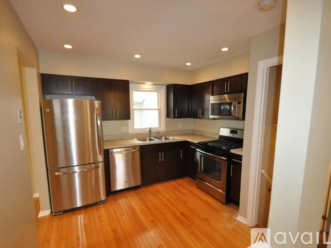 A kitchen with a refrigerator, oven, and microwave.
