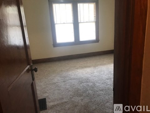 A room with a window and a carpeted floor.