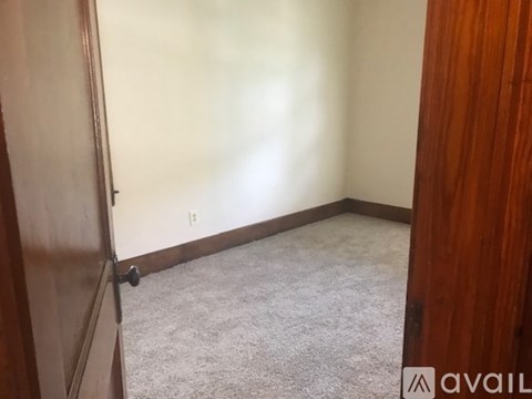 A room with a carpeted floor and a door on the left.