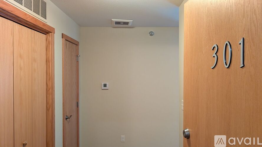 A room with a door numbered 301 and a wooden door on the left.