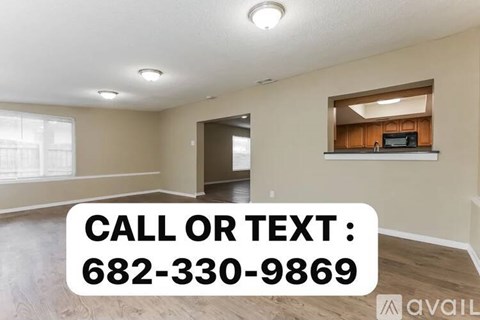A room with a window and a wooden shelf with a phone number displayed on it.