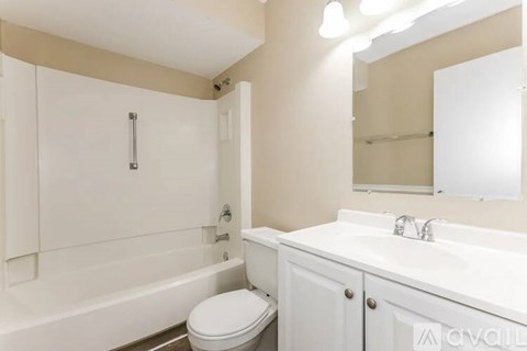 A white bathroom with a toilet, sink, and bathtub.