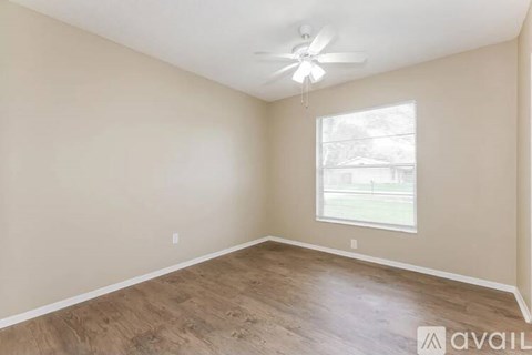 A room with a ceiling fan and a window.