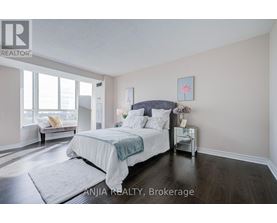 A bedroom with a large bed and a window seat.