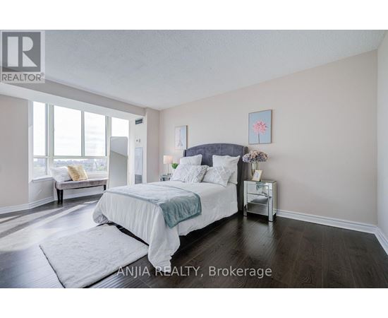A bedroom with a large bed and a window seat.