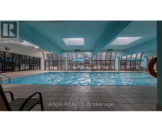 A large indoor swimming pool with a glass wall on one side.