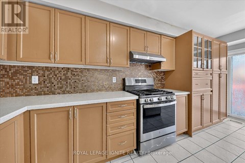 A kitchen with brown cabinets and a tiled backsplash.