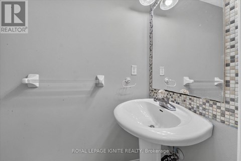 A white sink in a bathroom with a mirror above it.