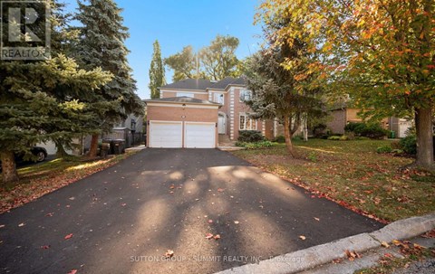 A residential street with a house and trees in autumn.