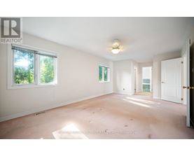 A large empty room with a window and a door.
