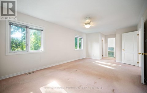 A large empty room with a window and a door.