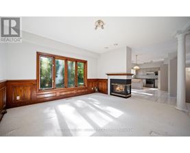 A spacious living room with a fireplace and large windows.
