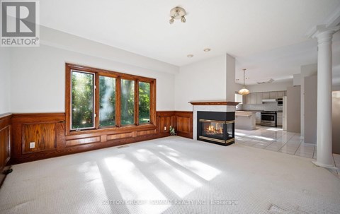 A spacious living room with a fireplace and large windows.