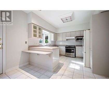 A white kitchen with a stove top oven and microwave.