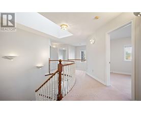 A spacious room with a wooden staircase and white walls.