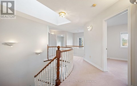 A spacious room with a wooden staircase and white walls.