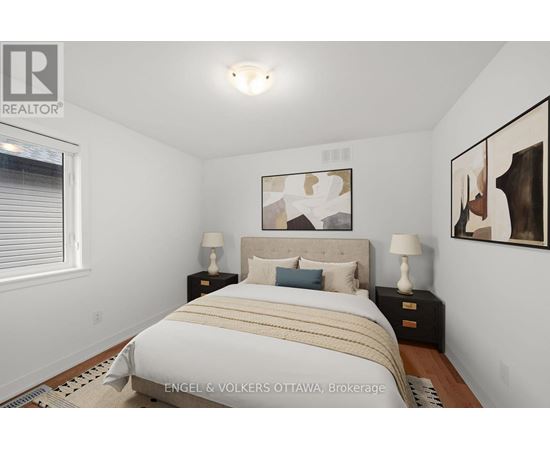 A bedroom with a bed, two nightstands, and a painting on the wall.