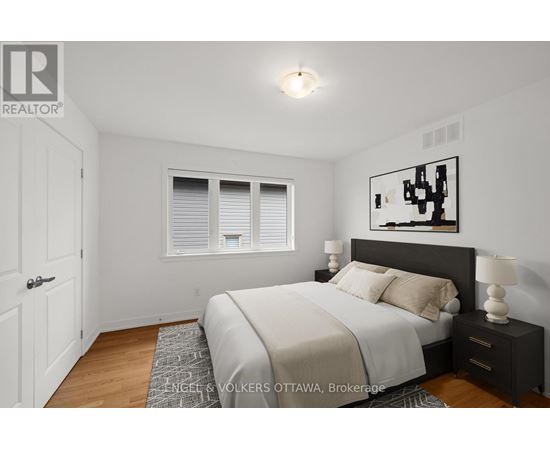 A bedroom with a bed, nightstand, and window.