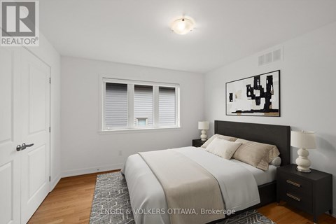A bedroom with a bed, nightstand, and window.