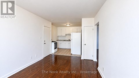 A white kitchen with a refrigerator, microwave, and oven.