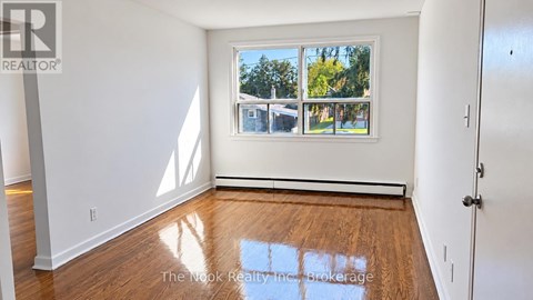 A room with a window and wooden floors.