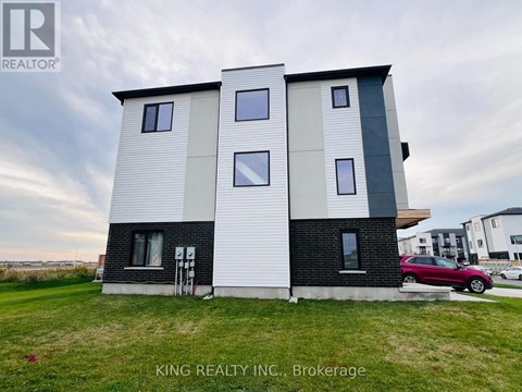 A modern two-story house with a white and black exterior is for sale.