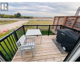 A balcony with a table and chairs overlooking a field.