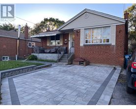 A house with a brick exterior and a driveway in front.