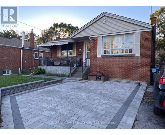 A house with a brick exterior and a driveway in front.