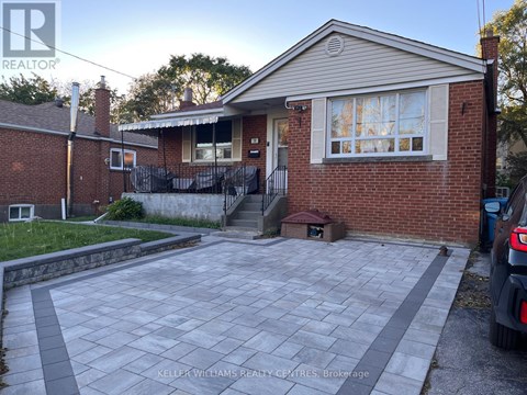 A house with a brick exterior and a driveway in front.